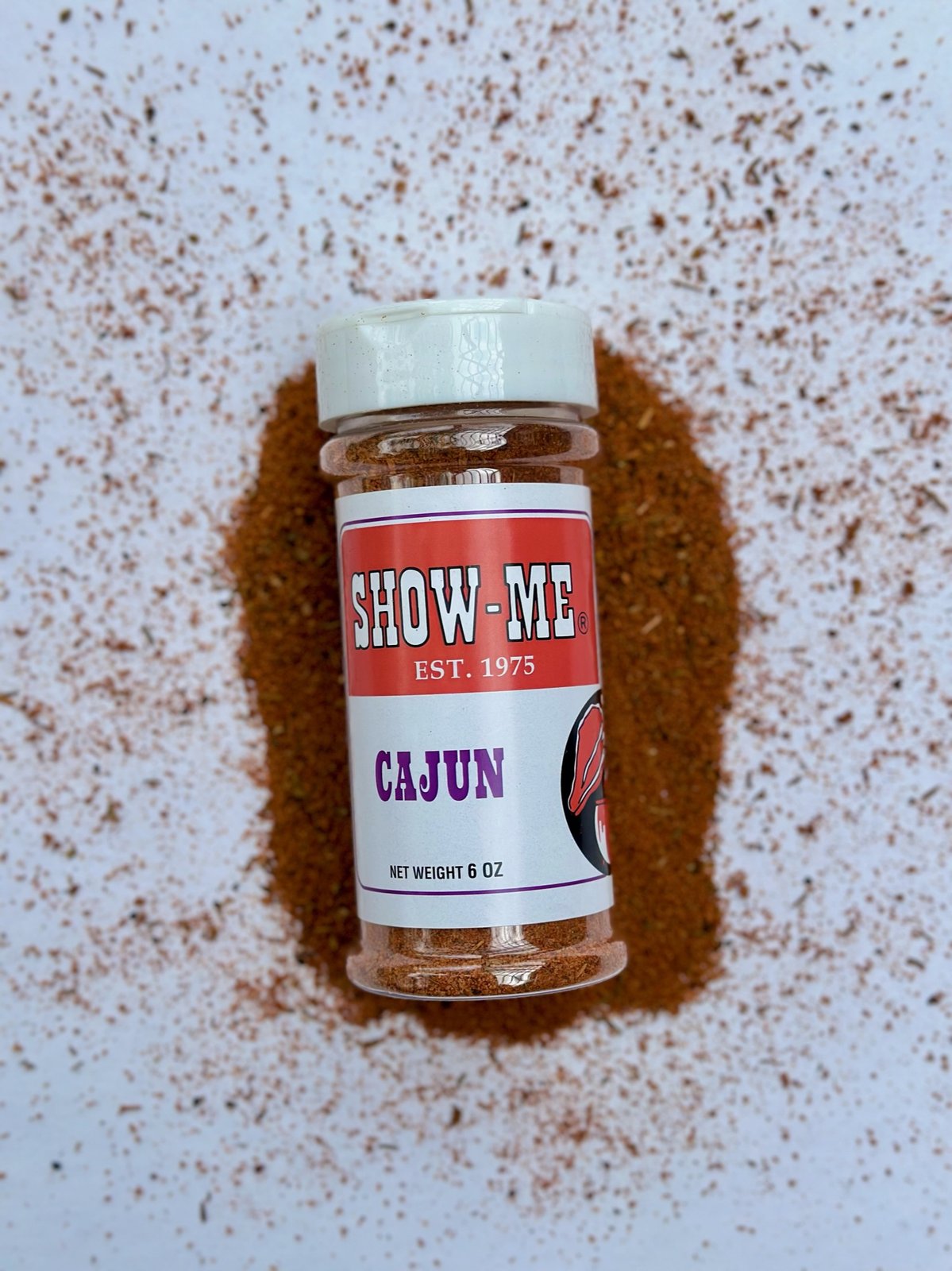 Show-Me® Cajun seasoning shaker on a bed of Cajun spice