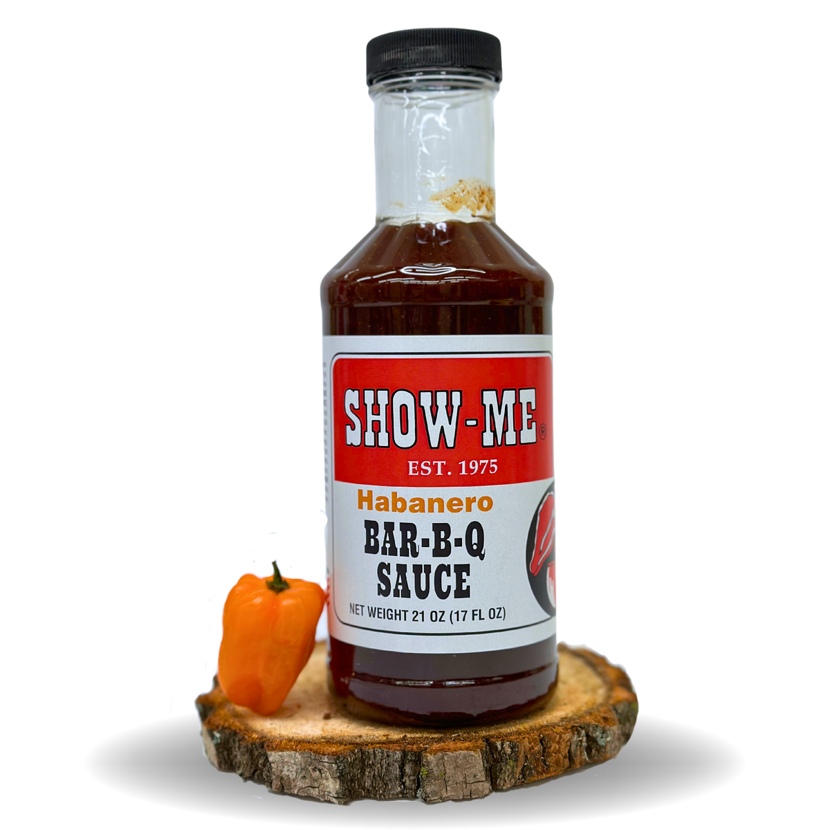 Show-Me® Habanero Bar-B-Q Sauce pint bottle beside an orange habanero pepper on a wood round
