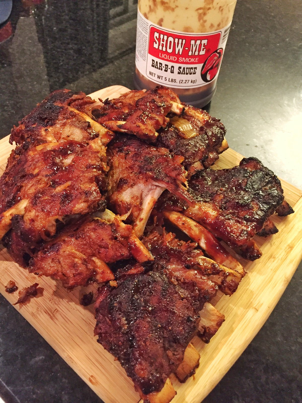 Smoked chicken wings glazed with Show-Me® Bar-B-Q Sauce on a wooden cutting board