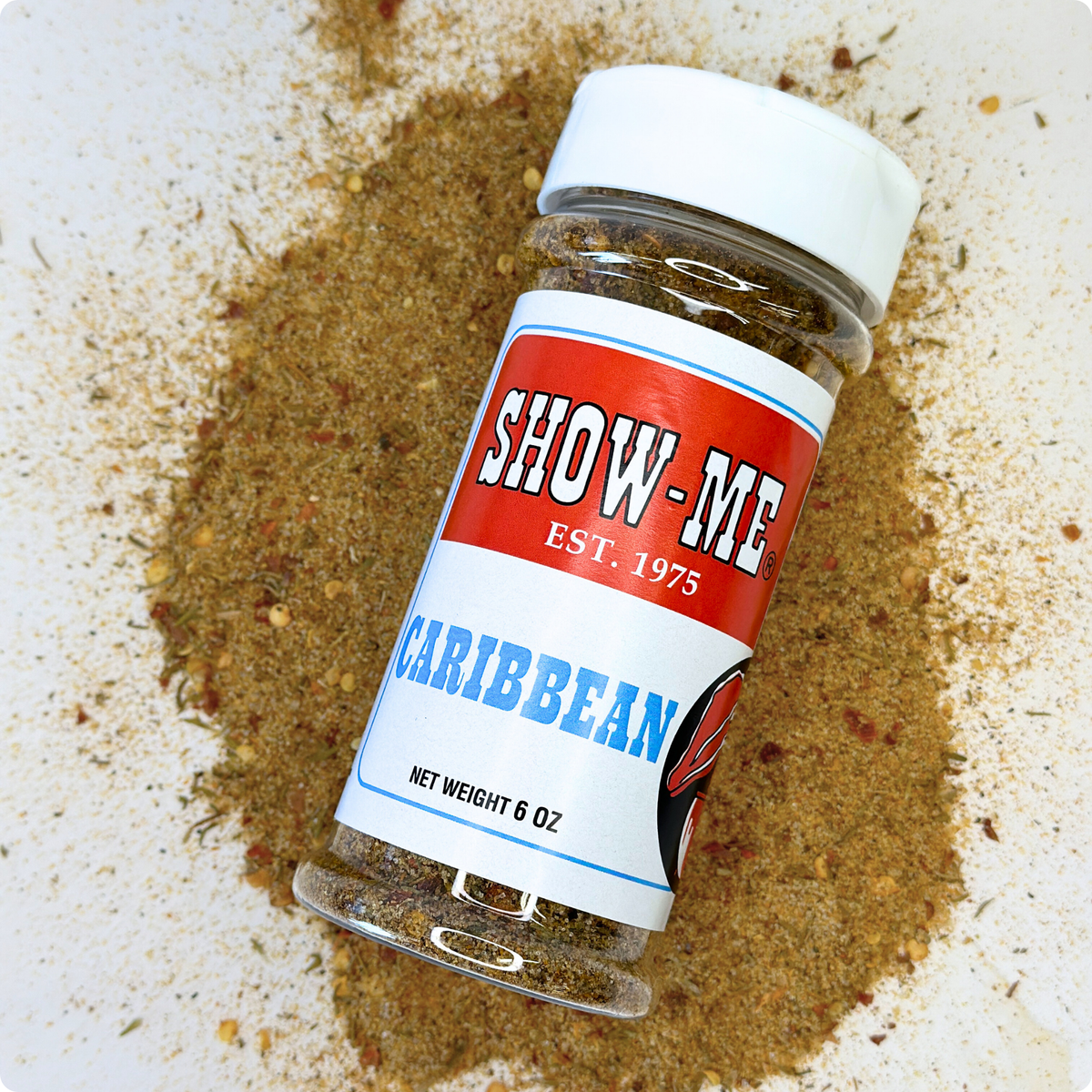 Show-Me® Caribbean Seasoning 6 oz shaker lying on a pile of the seasoning blend