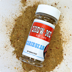 Show-Me® Caribbean Seasoning 6 oz shaker lying on a pile of the seasoning blend