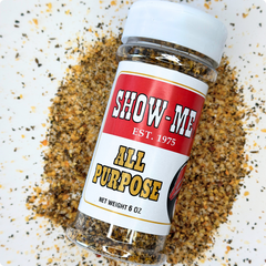 Show-Me® All Purpose Seasoning 6 oz shaker lying on a pile of the seasoning blend