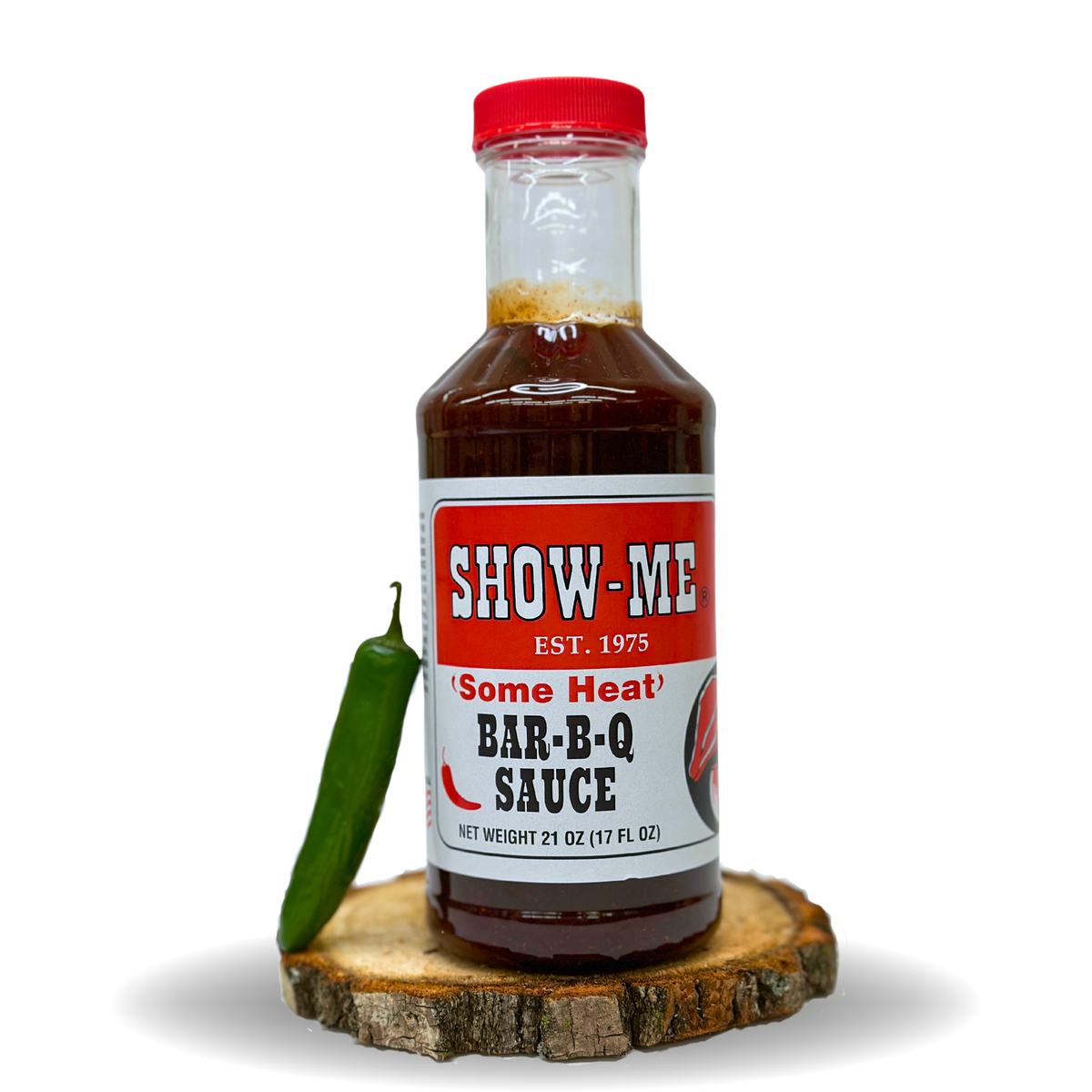 Show-Me® 'Some Heat' Bar-B-Q Sauce pint bottle beside a green chili pepper on a wood round